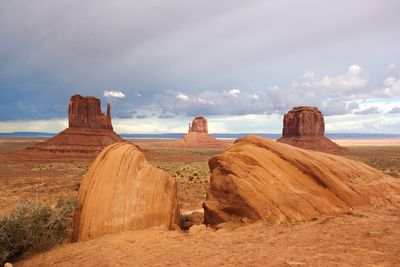 Scenic view of stack rocks at monument valley against cloudy sky