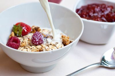 Milk pouring on food in bowl