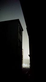 Low angle view of silhouette buildings against sky at night