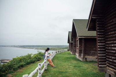 Full length of woman standing on shore against sky