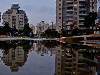 Reflection of buildings in puddle on lake