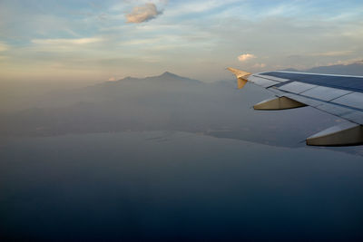 Airplane flying over mountains against sky