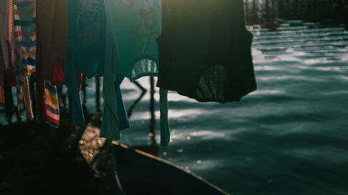 Close-up of clothes hanging on window by lake