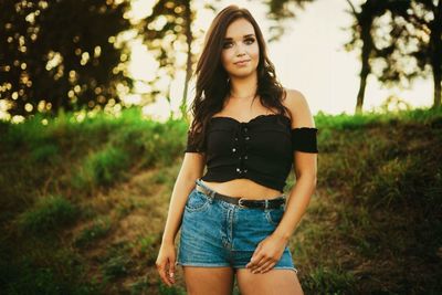 Portrait of beautiful young woman against trees