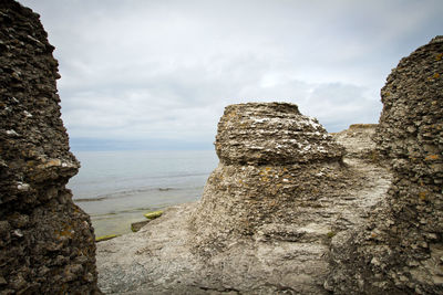 Rock formations by sea against sky
