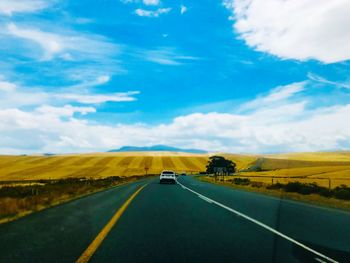 Car moving on road against sky