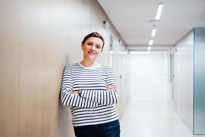 Portrait of young woman standing at home