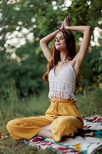 Young woman looking away while sitting at park