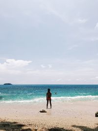 Full length of man standing on beach against sky