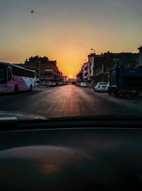 Cars on road against sky during sunset