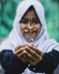 Portrait of woman holding sparklers