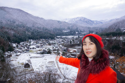 Portrait of beautiful woman in snow against mountains