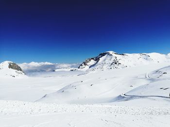 Scenic view of snow mountains against blue sky