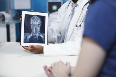 Midsection of woman using digital tablet