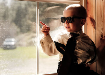 Full length of boy holding window