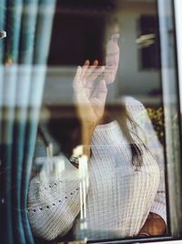 Close-up of woman looking through window