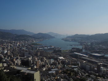 High angle view of townscape by sea against clear sky