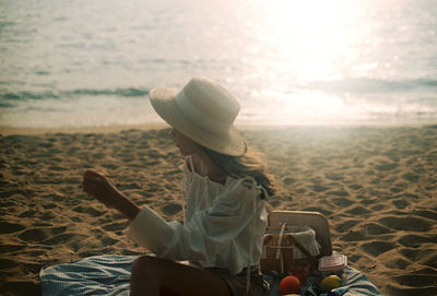 Rear view of woman sitting on beach