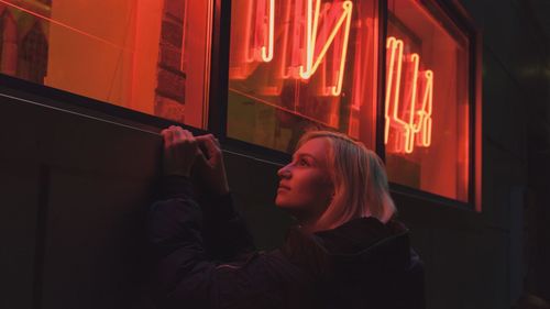 Woman looking at illuminated window