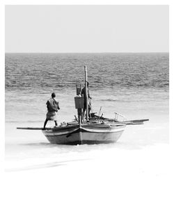 Man in boat on sea against sky