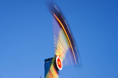 Low angle view of illuminated spinning propeller against sky