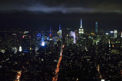 Illuminated cityscape against sky at night