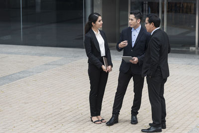 Business people discussing while standing in front of office