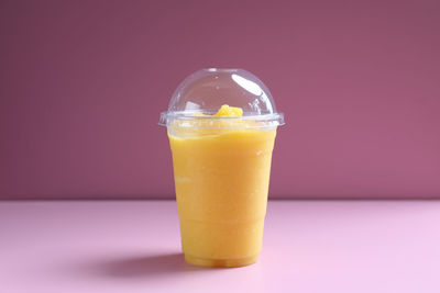 Close-up of drink in glass against pink background