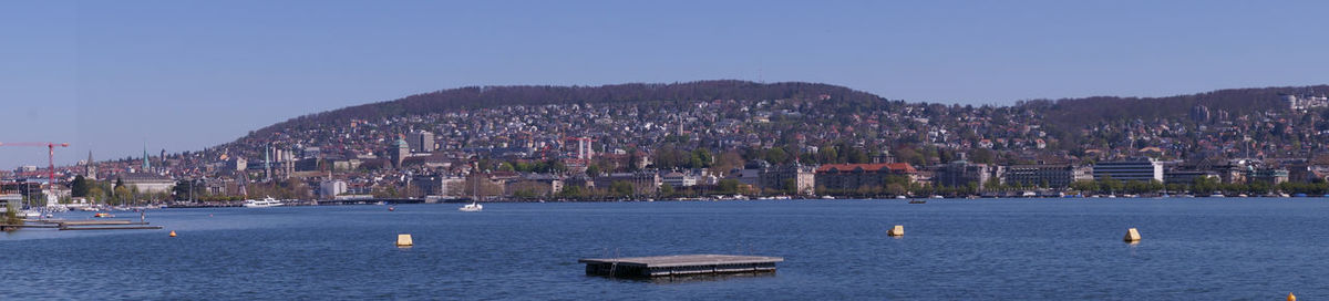 Sailboats in sea against clear blue sky