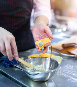 Midsection of man preparing food in kitchen at home