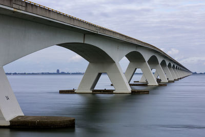 Low angle view of bridge over river against sky