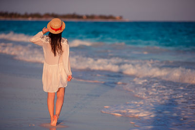 Rear view of woman walking on beach