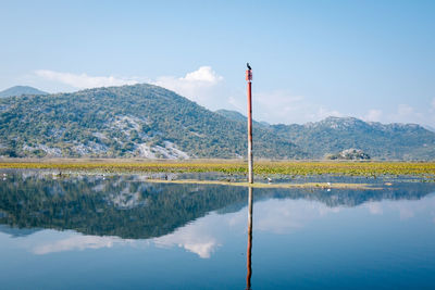 Scenic view of lake by mountain against sky