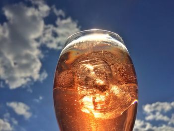 Close-up of beer glass against sky