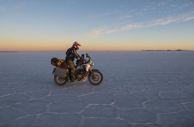 Man riding his touring motorbike on the salt flats of uyuni in bolivia