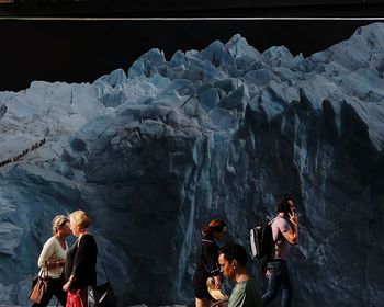 People standing in cave against sky during winter