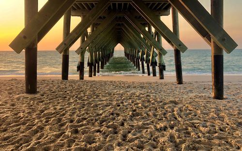 View of pier on beach against sky