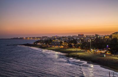 View of city at waterfront during sunset