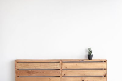 Potted plant on table against wall