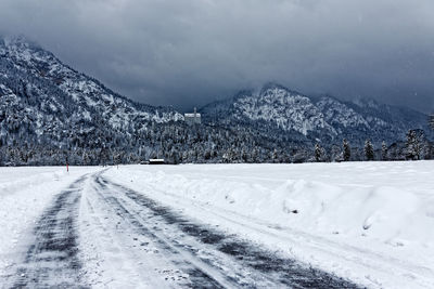 Snow covered road against mountains
