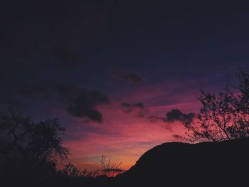 Low angle view of silhouette mountain against sky at sunset