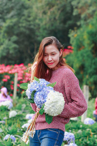 Portrait of a smiling young woman holding flower