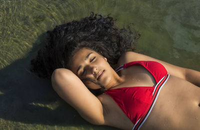 High angle portrait of woman lying down in water