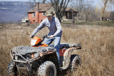 Young man riding on quadbike on grassy field