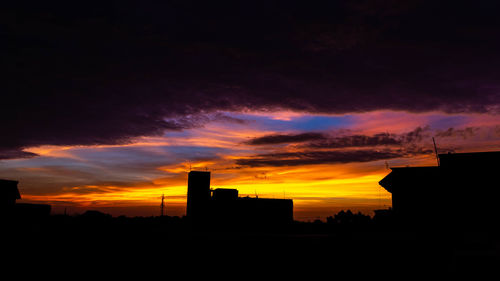 Silhouette buildings against sky during sunset