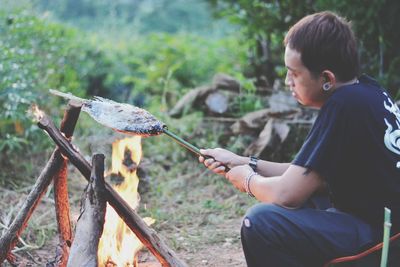 Side view of boy sitting on land