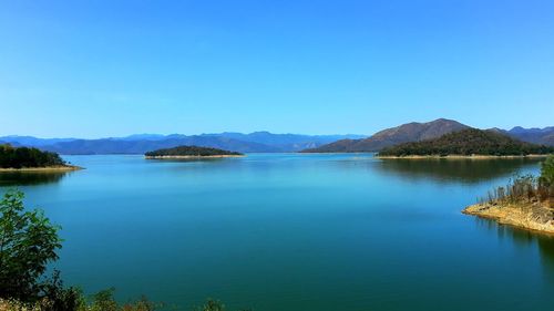 Scenic view of lake against clear blue sky