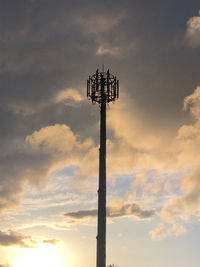 Low angle view of communications tower against sky during sunset