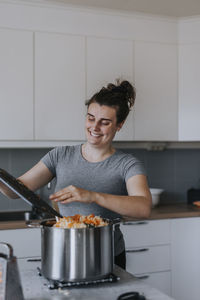 Smiling woman in kitchen preparing food