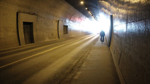 Rear view of man walking in subway tunnel